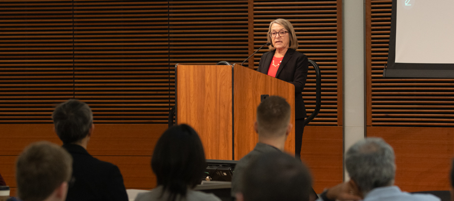 Laura Patterson gives a keynote address on a stage in front of a seated audience