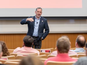 Didier Contis speaks in front of a seated audience.