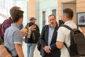Four people in conversation in an office hallway