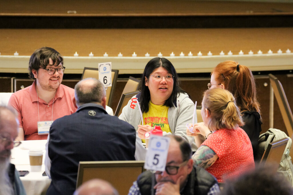 A small group of people in conversation at a round table.