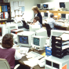 A group of people work at computers in an office in the 1990s