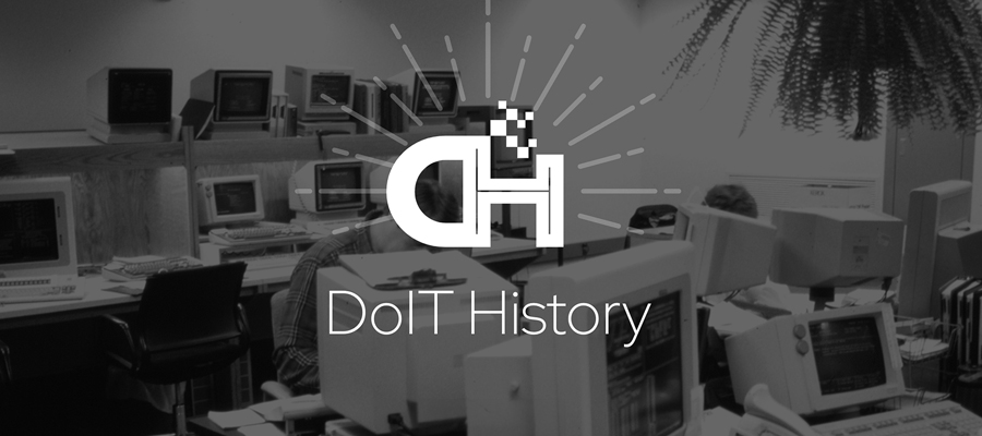 An office full of computers and large monitors from the 80s with the DoIT History logo.