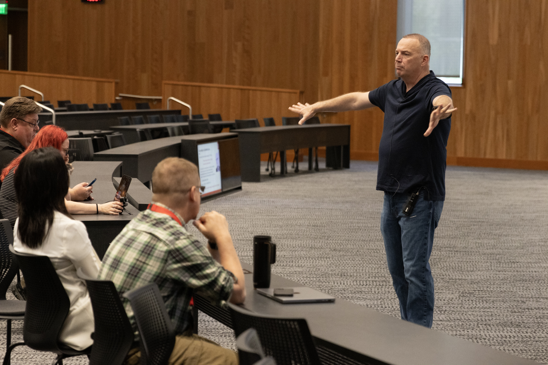 Patrick McDaniel gestures with his arms outstretched while delivering his keynote address. (Photo by Justin Masuga / DoIT Communications)
