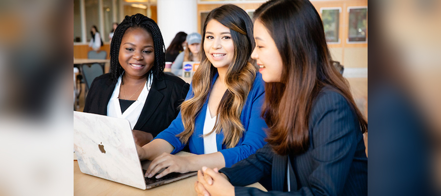 women of different cultural backgrounds using a computer