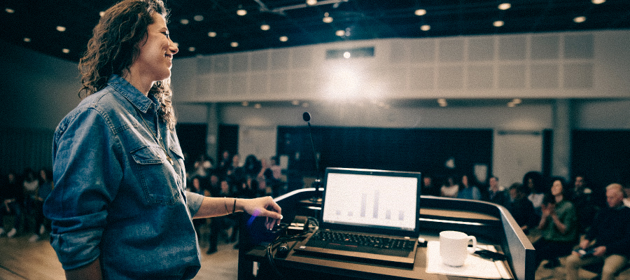 Person presenting at a podium in front of an audience