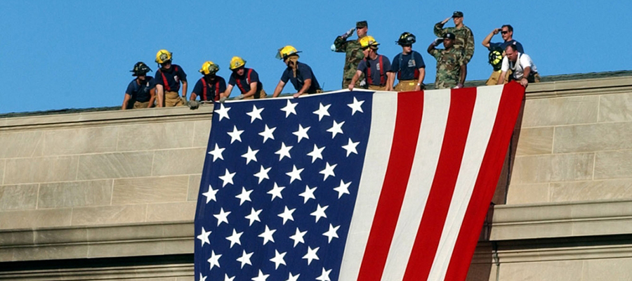 Firefighters and soldiers unfurl flag