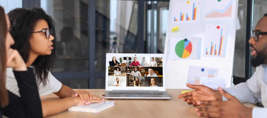 People in meeting face-to-face and with colleagues on Zoom