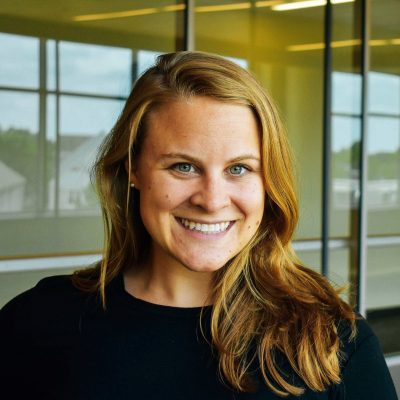 woman with blonde hair and black shirt in front of a window
